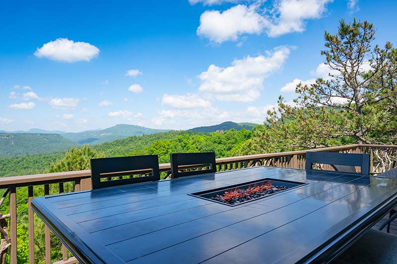 This is a picture of a table on a deck overlooking mountains in Sapphire Valley